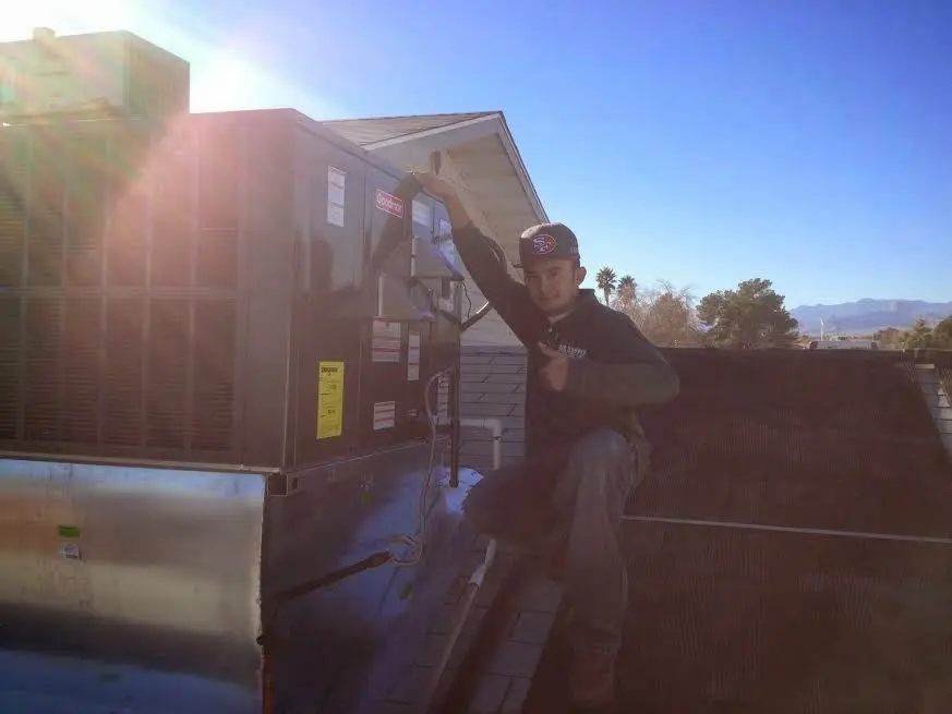 HVAC technician performing AC Tune-Up on a rooftop unit in Englewood